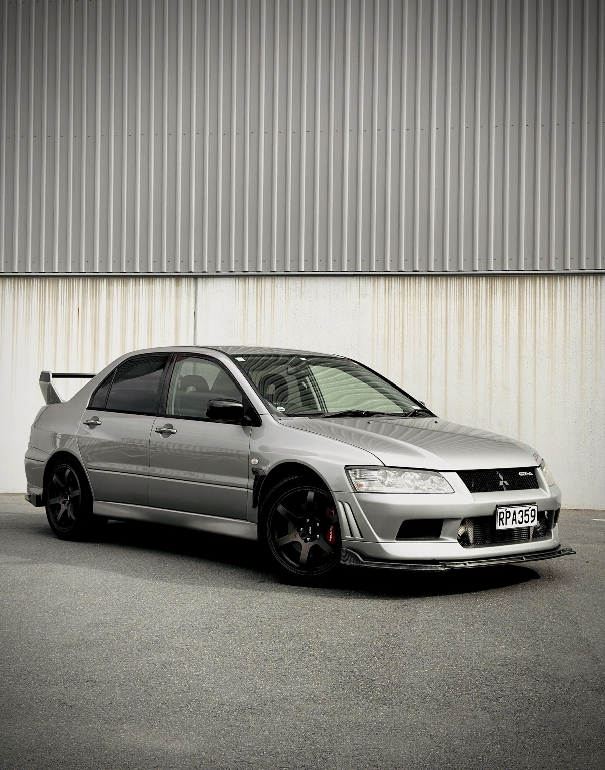 Silver Japanese performance sedan photographed outside a workshop